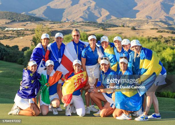Suzann Pettersen of Norway the Captain and The European Team pose with the Solheim Cup after the final day singles matches had resulted in a 14-14...