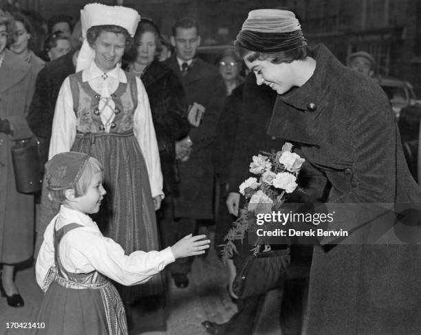 Five year old Ann Evander presents a bouquet to Princess Margaretha of Sweden as she attends the opening of the Christmas Fair at the Swedish Church...