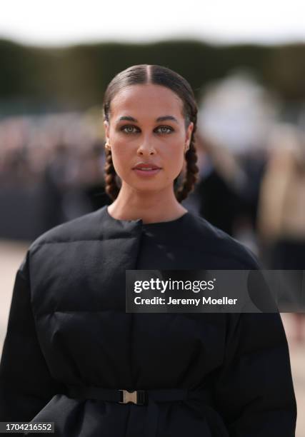 Sarah Lysander is seen outside Dior show wearing small golden crystal Dior earrings, black puffer cropped Dior jacket, black long Dior skirt, black...