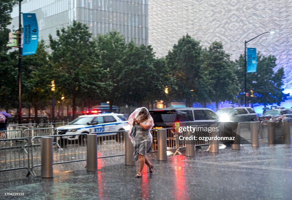 Des piétons utilisant des parapluies pour s’abriter de la pluie alors qu’ils marchent dans la rue à New York