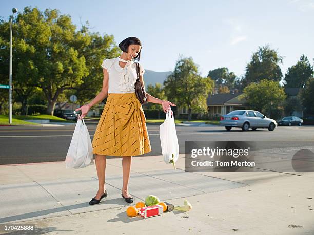 mujer frustrada caída de comestibles en la acera - woman carrying tote bag fotografías e imágenes de stock