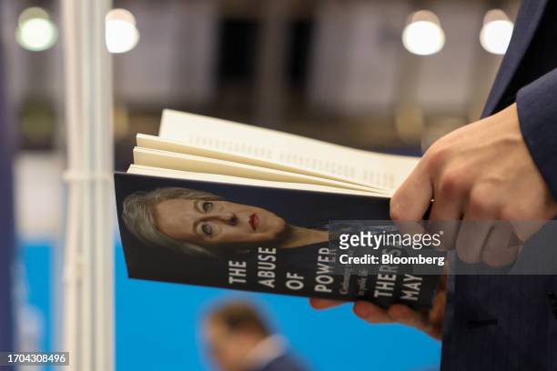 An attendee reads a copy of "The Abuse Of Power" by Theresa May on the day three of the UK Conservative Party Conference in Manchester, UK, on...