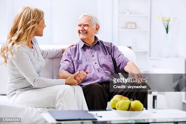 altenpfleger sitzung n der couch mit ein älterer mann - respite care stock-fotos und bilder