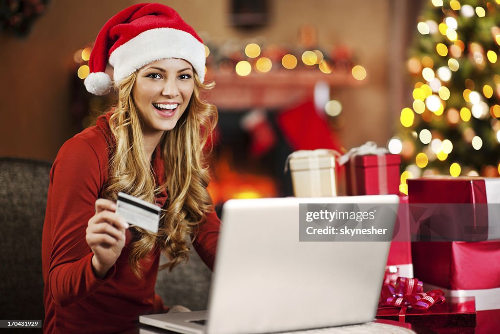 Hermosa mujer de compras en línea para Navidad.