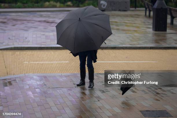 Man loses his hat as the first rain and wind of Storm Agnes approaches the UK on September 27, 2023 in Liverpool, United Kingdom.