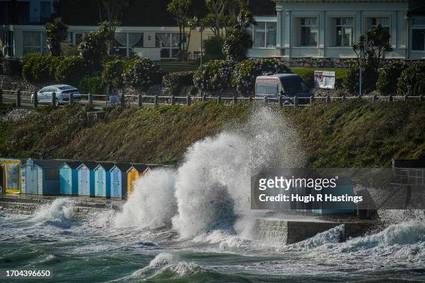 Row of beach huts are swamped by waves at Castle Beach on September 27, 2023 in Falmouth, Cornwall, England.