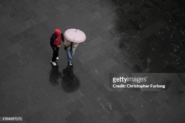 People brave the first rain and wind of Storm Agnes as it approaches the UK on September 27, 2023 in Liverpool, United Kingdom.