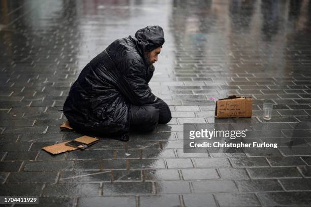 Man begs on the street as the rain and wind of Storm Agnes approaches the UK on September 27, 2023 in Liverpool, United Kingdom.