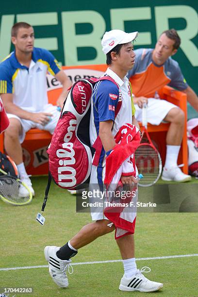 Kei Nishikori of Japan leaves the court after loosing his doubles match with Milos Raonic of Canada against Philipp Kohlschreiber of Germany and...