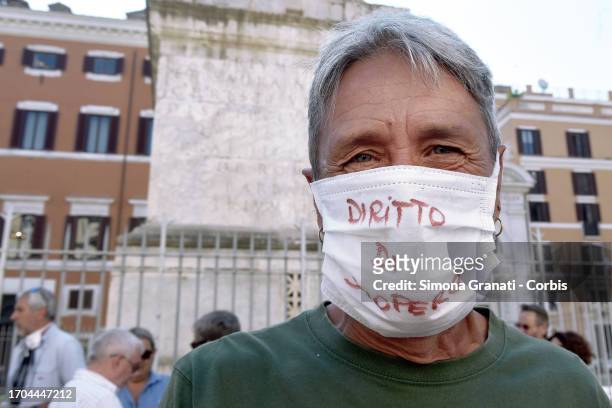 Workers belonging to the USB union in front of Palazzo Chigi guarded by the police wear masks on their face with the slogan "right to strike" on...