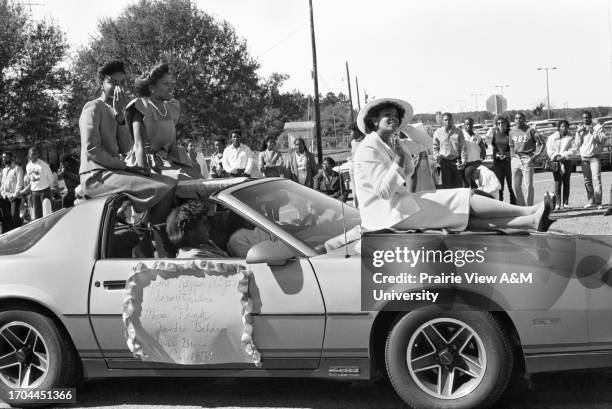 Miss Alpha Kappa Alpha sitting on Chevy Camaro during the 1984 Prairie View A&M homecoming parade in Prairie View, Texas.