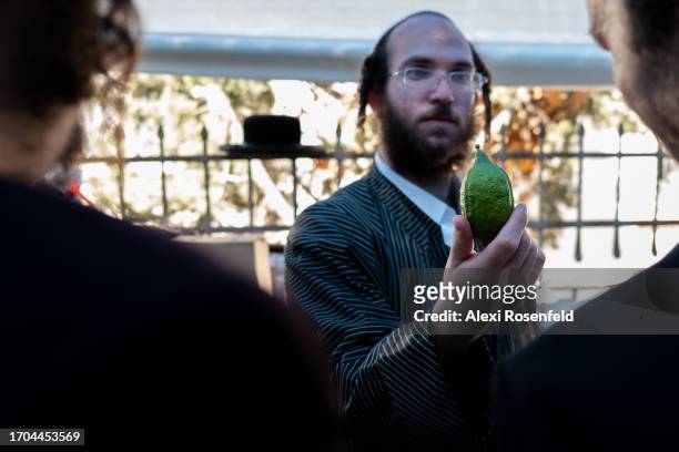 An Ultra-Orthodox man holds up an etrog for customers at a specialty market in the Ultra-Orthodox neighborhood of Mea Shearim on September 27, 2023...