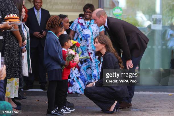 Prince William, Prince of Wales and Catherine, Princess of Wales receive posies from Akachi Humzah Ayla-May and Mazin at the end of a visit to the...