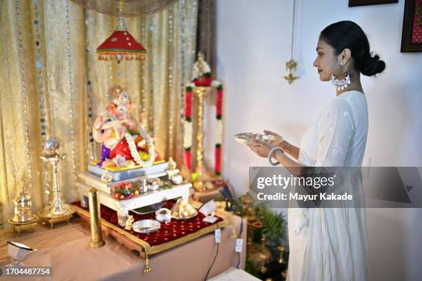 teenage girl performing pooja, during ganesh festival at home - puja stock pictures, royalty-free photos & images