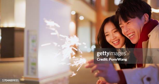 couple play sparkler together - chinese people new year stock pictures, royalty-free photos & images
