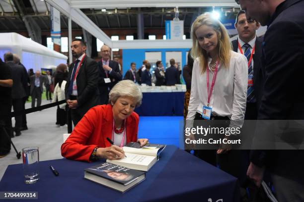 Britain's former Prime Minister, Theresa May, signs copies of her book on the third day of the Conservative Party Conference on October 03, 2023 in...