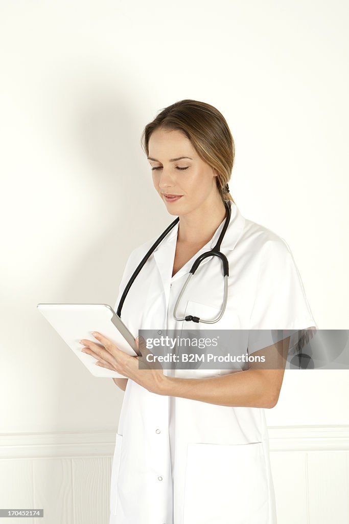 Portrait Of Female Doctor Using Digital Tablet