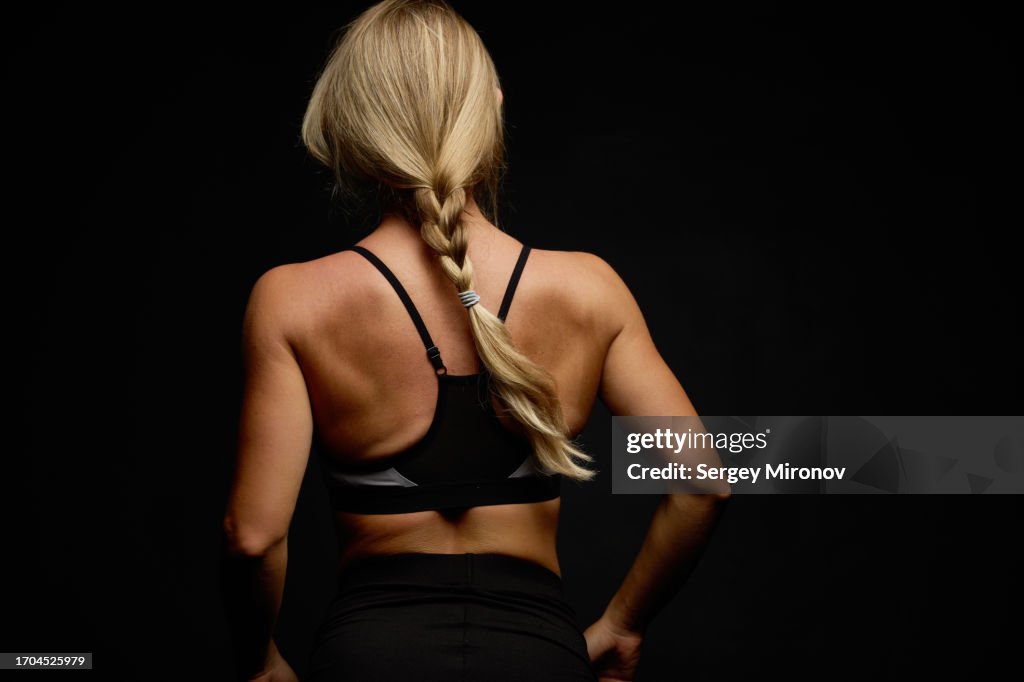 Rear view of fitness woman on black background