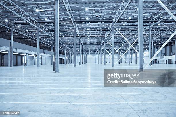 vast empty warehouse with white floors and silver beams - 大賣場 個照片及圖片檔