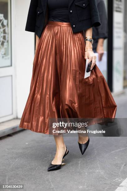 Guest is seen wearing a pleated wide copper skirt outside Dries Van Noten show during the Womenswear Spring/Summer 2024 as part of Paris Fashion Week...