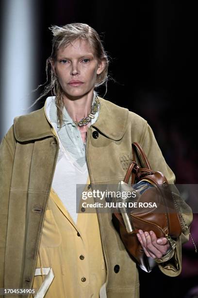 Musician Sybil Buck walks the runway to present a creation by Miu Miu during the Paris Fashion Week Womenswear Spring/Summer 2024 in Paris on October...