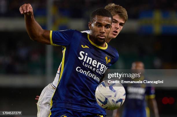 Isak Hien of Hellas Verona FC competes for the ball with Charles De Ketelaere of Atalanta BC during the Serie A TIM match between Hellas Verona FC...