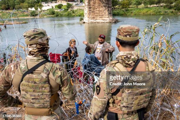 Venezuelan immigrant Louis Sanchez asks Texas National Guard troops to let his family pass through razor wire after they crossed the Rio Grande from...
