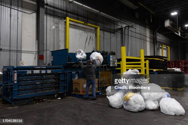 Worker loads plastic film into a baler at an ACME and Safeway Distribution Center in Denver, Pennsylvania, US, on Tuesday, June 20, 2023. More than...