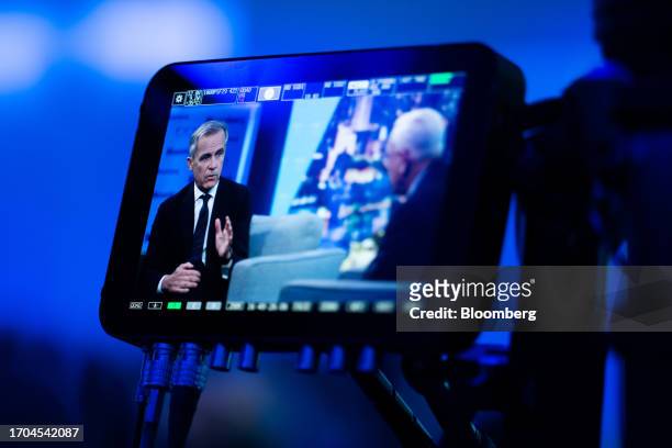 Mark Carney, United Nations special envoy for climate action and finance, left, displayed on a monitor during an interview for an episode of "The...
