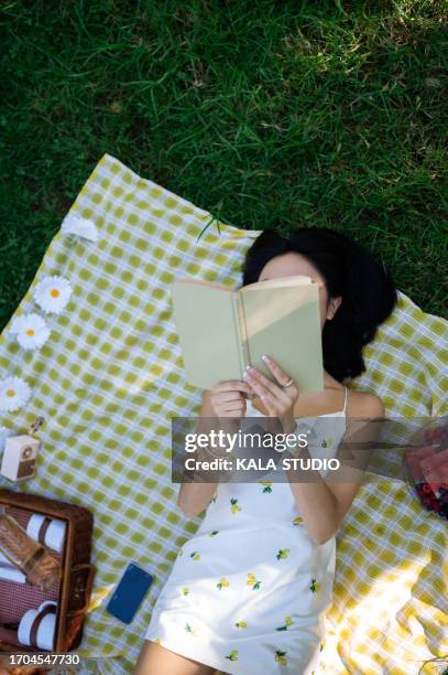 top view of a woman reading a book in the park - mujer leyendo libro en el parque fotografías e imágenes de stock