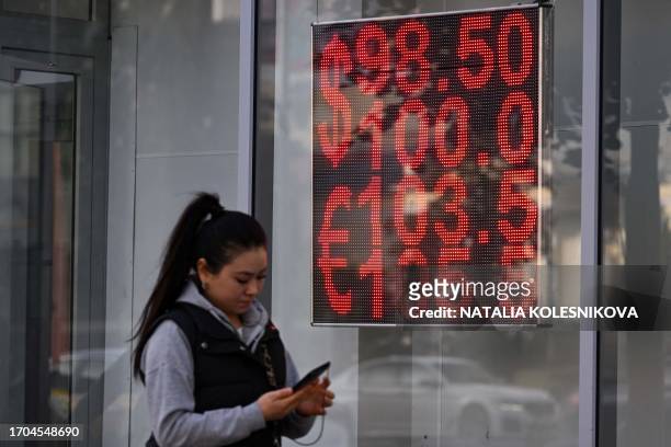 Woman walks past a currency exchange office in Moscow on October 3, 2023. Russia's currency fell against the dollar on October 3 weakening further on...