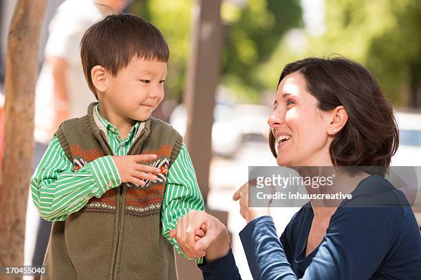 parent communicating with sign language - deafness stock pictures, royalty-free photos & images