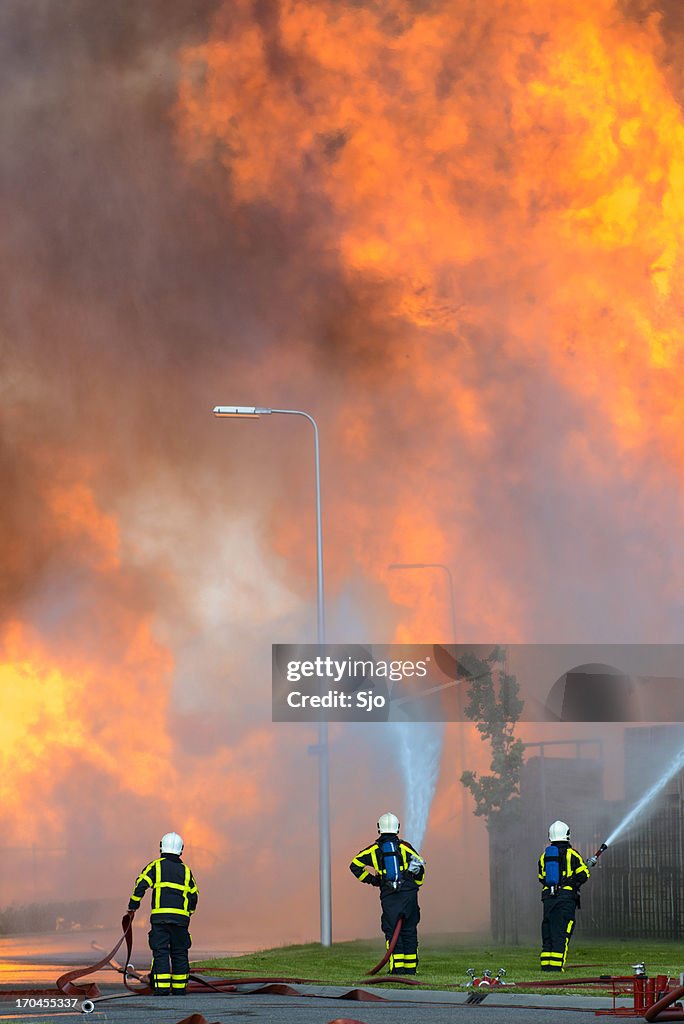 Fire fighting with huge flames in the background