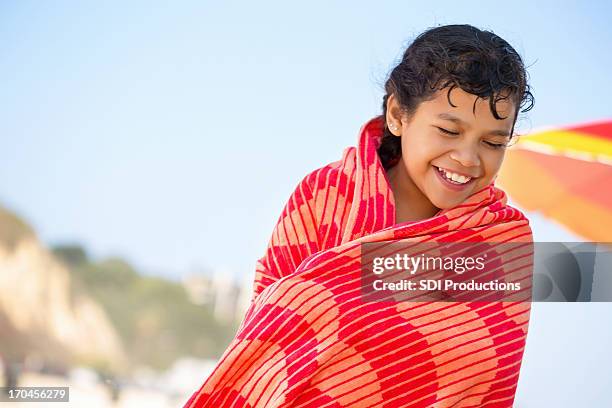 linda niña envuelto en toalla en la playa - envuelto en una toalla fotografías e imágenes de stock