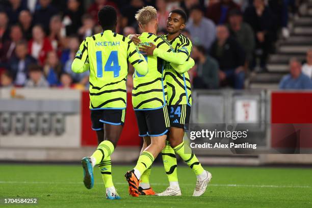 Reiss Nelson of Arsenal celebrates with team mates after scoring their sides first goal during the Carabao Cup Third Round match between Brentford...