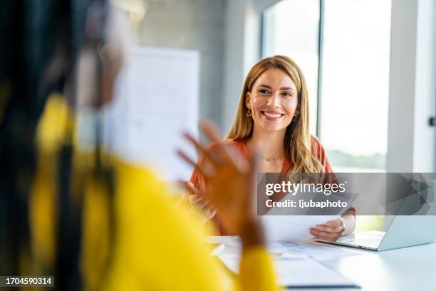 office manager talks to the new intern - consultation at office desk stockfoto's en -beelden