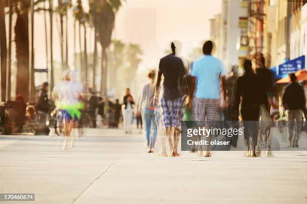 motion blurred pedestrians on boardwalk - crowded beach stock pictures, royalty-free photos & images