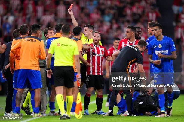 Jose Angel Carmona of Getafe CF receives medical treatment as Referee, Isidro Díaz de Mera Escuderos shows a red card during the LaLiga EA Sports...