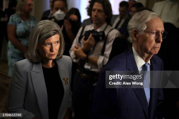 Senate Minority Leader Mitch McConnell and Sen. Joni Ernst listen during a news briefing after a weekly Senate Republican policy luncheon at the U.S....