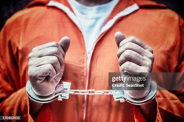 handcuffed gefangener in orange strampler - prisoner stock-fotos und bilder