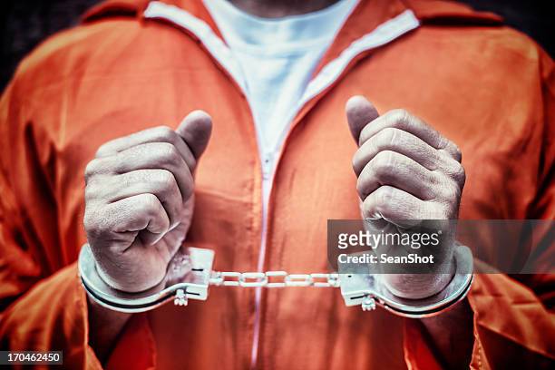 handcuffed prisoner in orange coveralls - guantanamo bay stock pictures, royalty-free photos & images