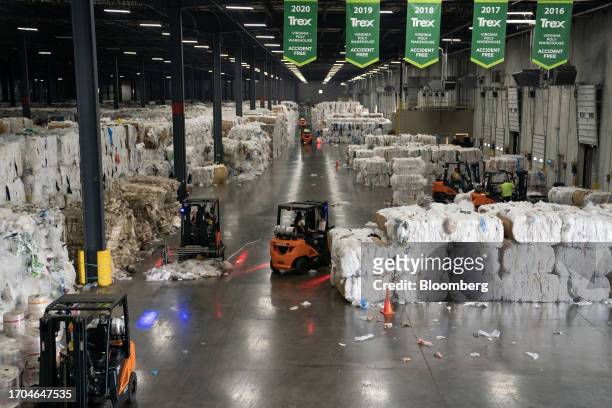 Workers unload and organize bundles of recycled plastics at the Trex manufacturing facility in Winchester, Virginia, US, on Wednesday, June 7, 2023....
