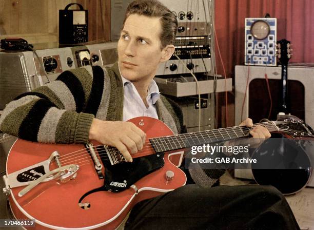 Circa 1960: Photo of American guitarist Chet Atkins posed with a Gretsch semi acoustic guitar in a recording studio circa 1960.