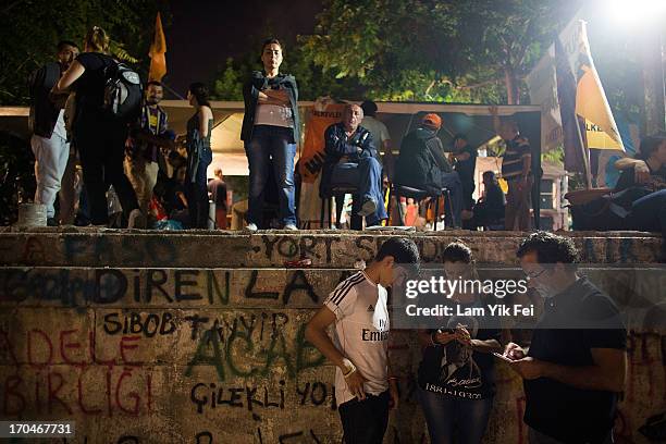 Protestors use mobile phones at Gezi Park as thousands of people gather at Taksim Square as government said will clear the protest within 24 hours,...