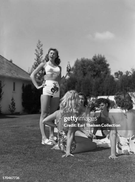 Swimming champion and future movie star Esther Williams enjoys a Coca Cola with her teammates from the Los Angeles Athletic Club at The Beverly Hills...