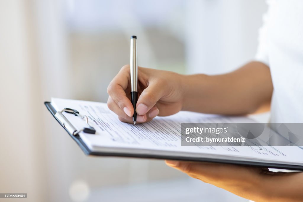 Klemmbrett und Stift im Büro halten