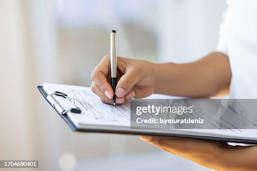 Holding clipboard and a pen in office