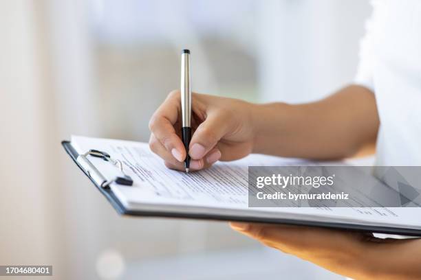 holding clipboard and a pen in office - employee survey stock pictures, royalty-free photos & images