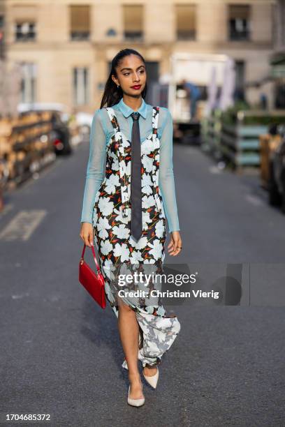Malvika Sheth wears red bag, dress with floral print, black tie, turquoise button shirt, beige heels, sunglasses during the Womenswear Spring/Summer...
