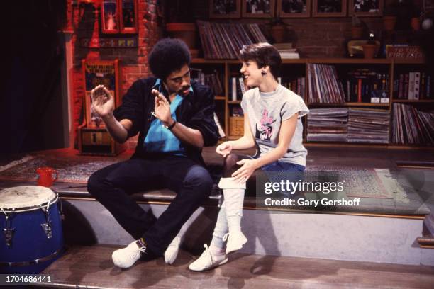 View of American Rock musician Jon Butcher , of the group Jon Butcher Axis, and MTV VJ Martha Quinn, both sit on a low stage during an interview on...